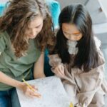 A mother and daughter bond over coloring on a cozy couch, enjoying quality family time.